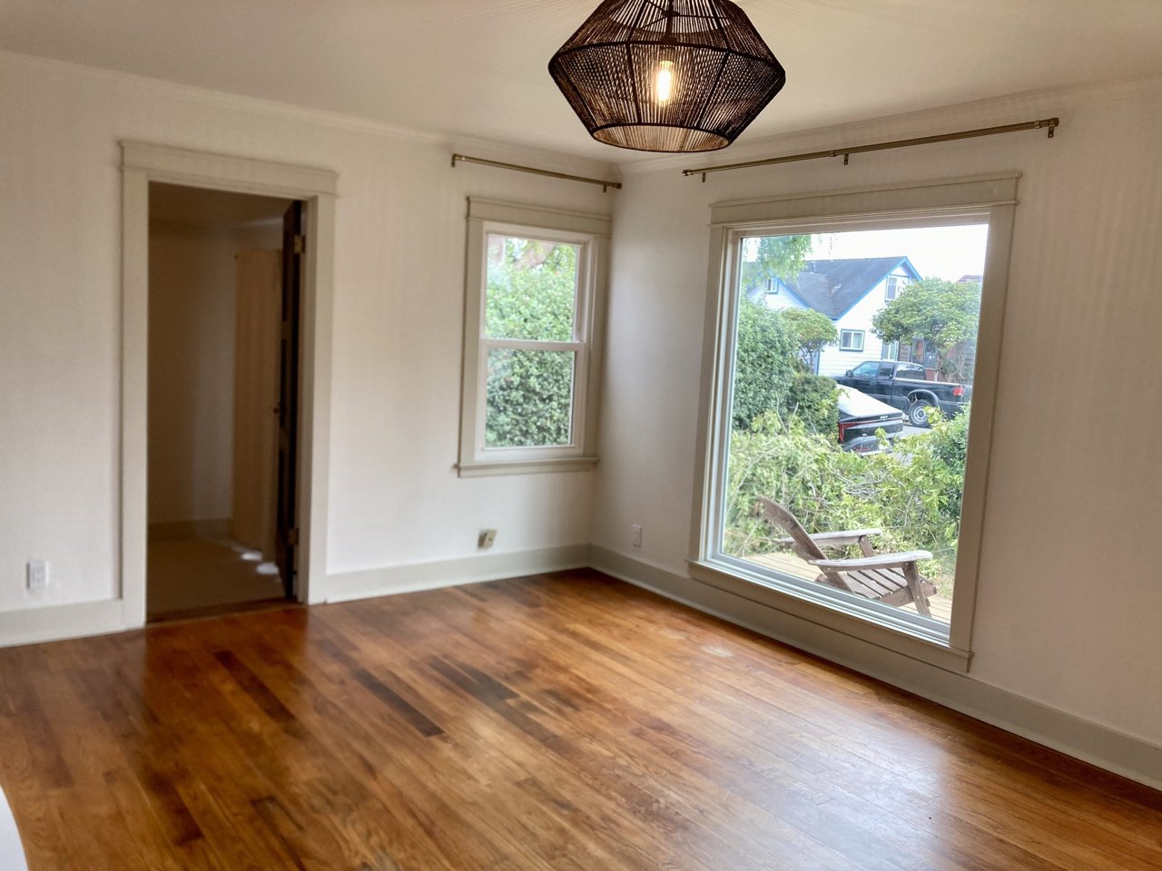 Finished interior with a large picture window and wood flooring