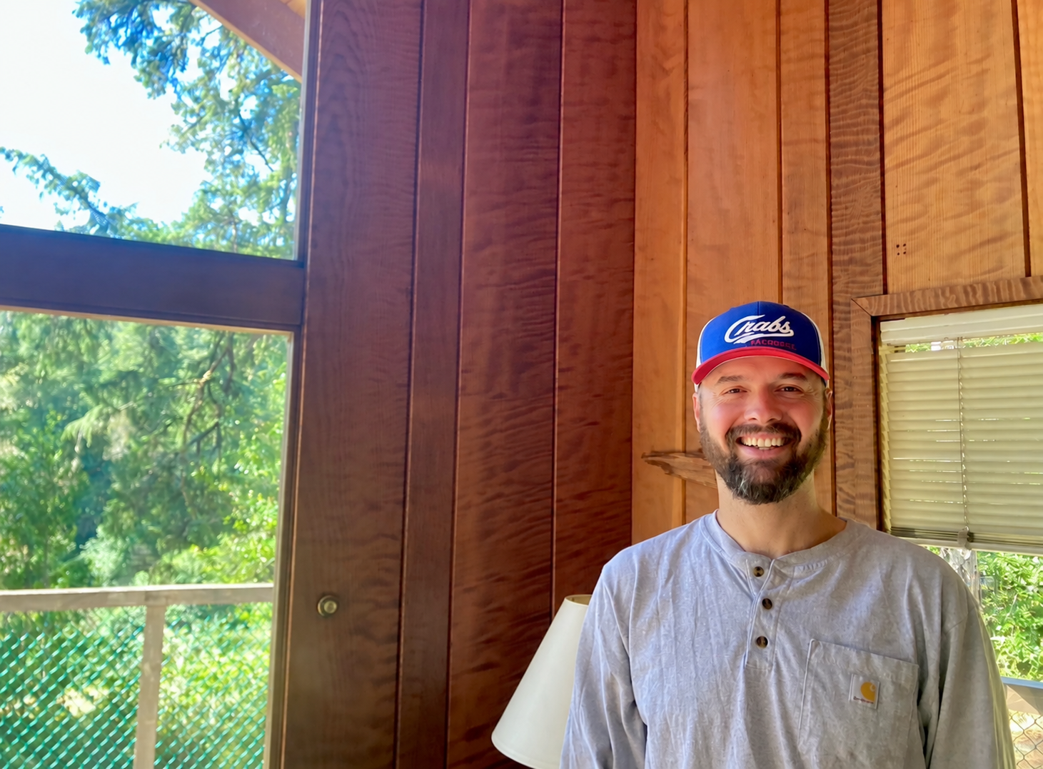 Layne Martin in a wood-paneled room beside a large window