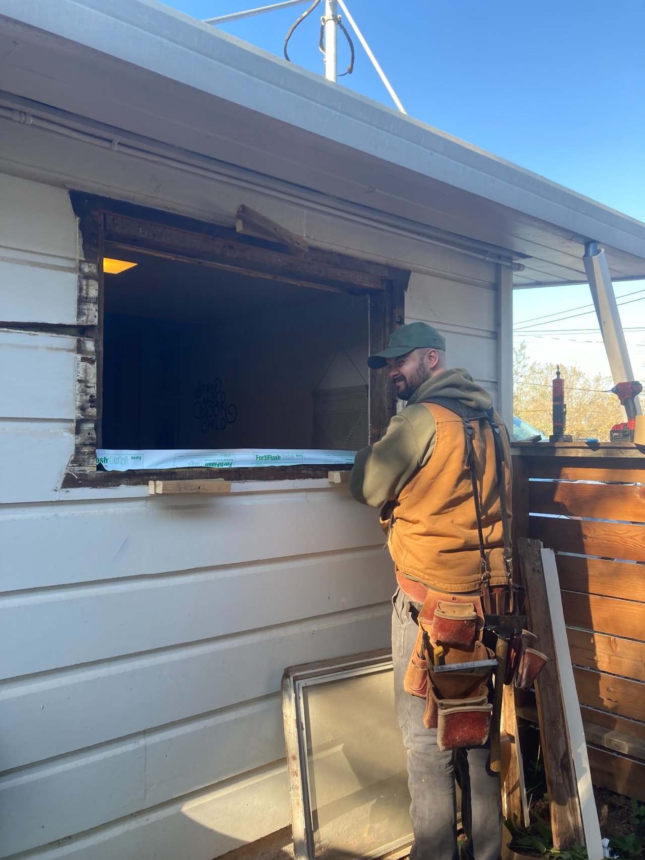 Layne Martin wearing a tool belt while preparing a window opening