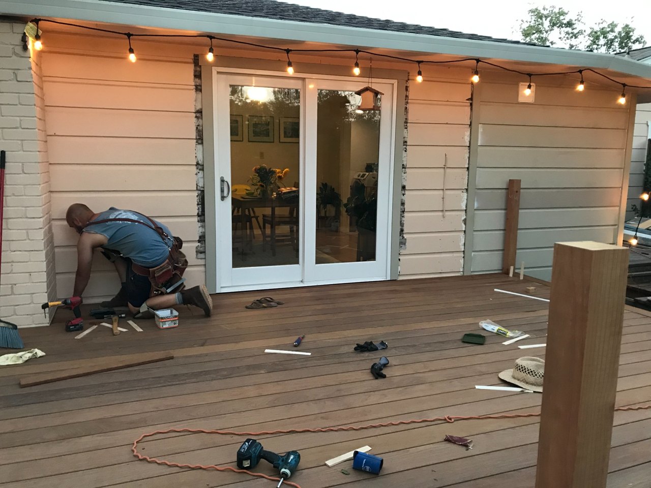 Patio door installation in progress beside a wood deck