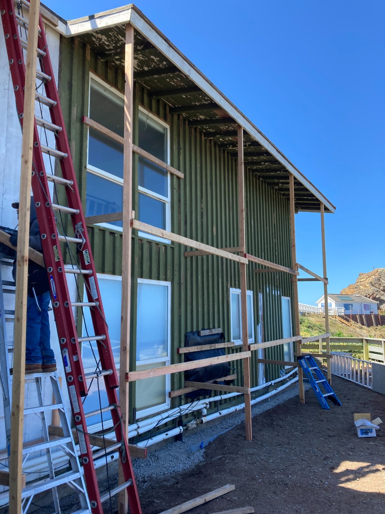 Commercial window openings and exterior work in progress beside ladders