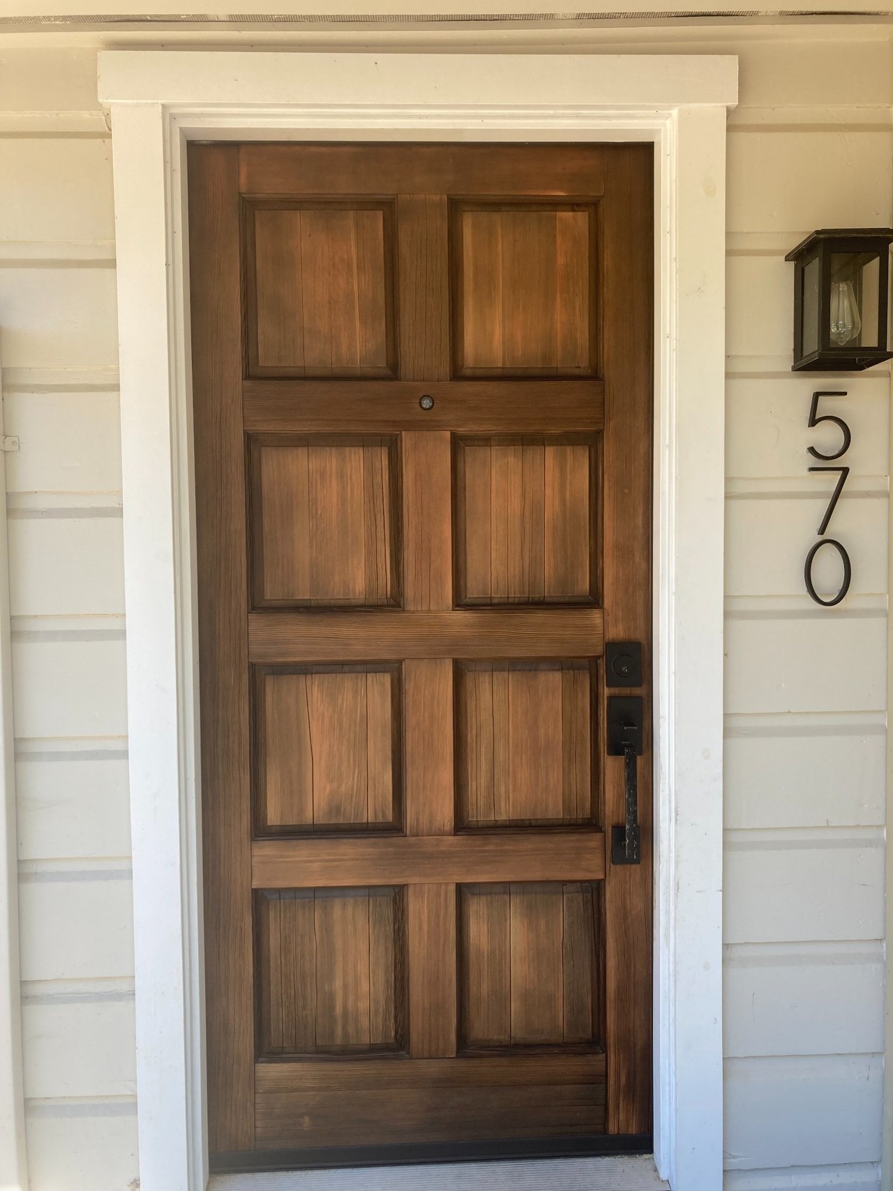 Finished wood entry door and white trim